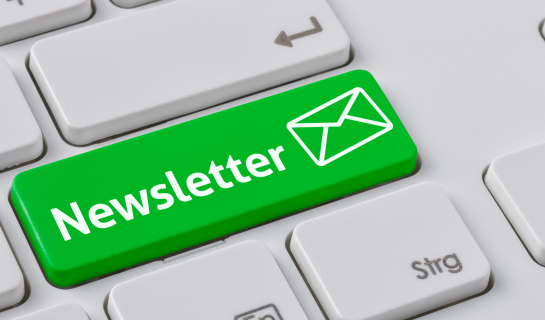 A grey keyboard with a single bright green key has the word Newsletter and an envelope icon in white.